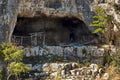 Panorama with high vertical limestone rocks and niches, ruins of former rock monastery